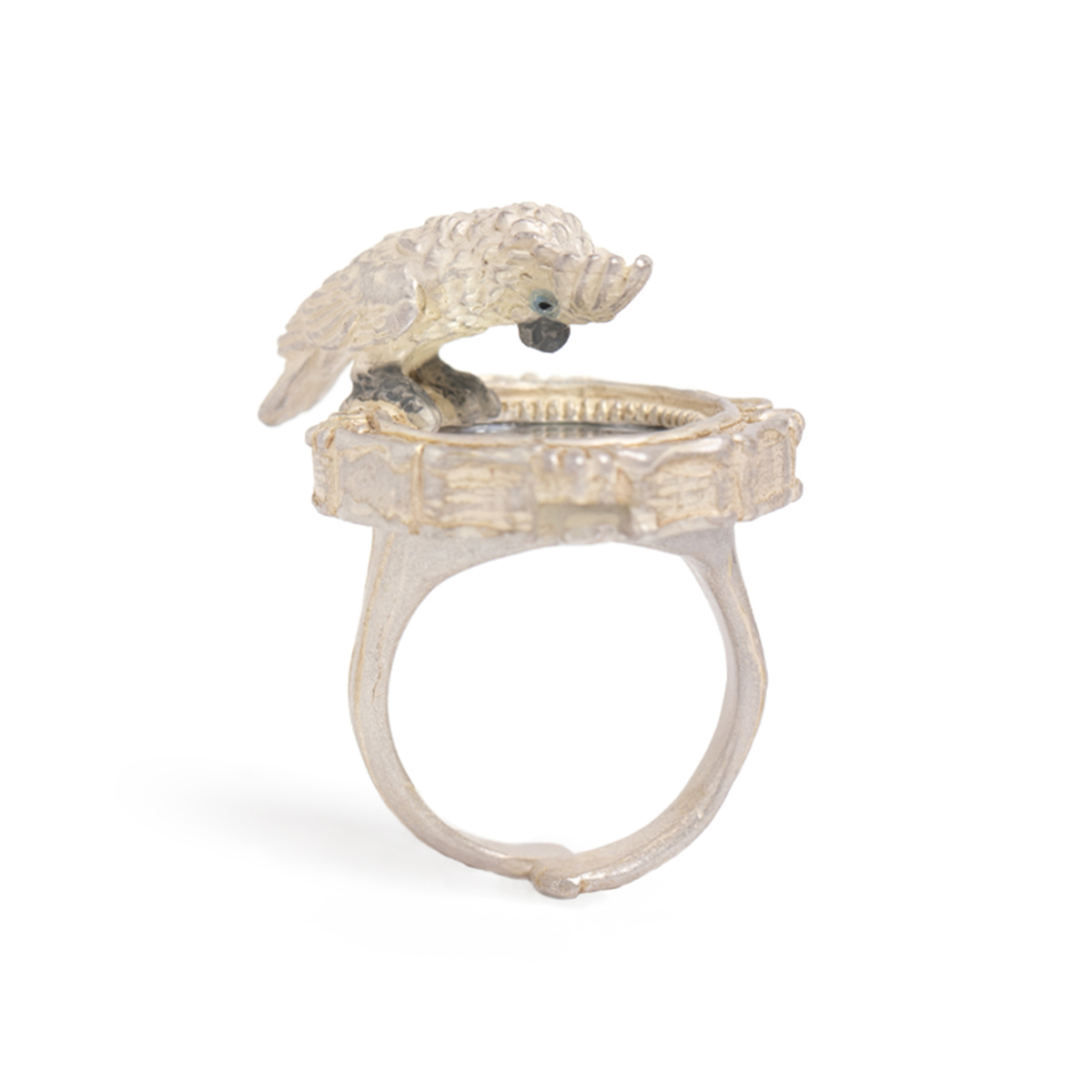 鏡をのぞき込むタイハクオウムをモチーフにした遊び心あるリング